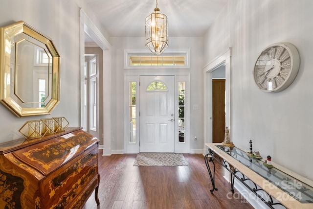 foyer entrance with dark hardwood / wood-style floors and a notable chandelier