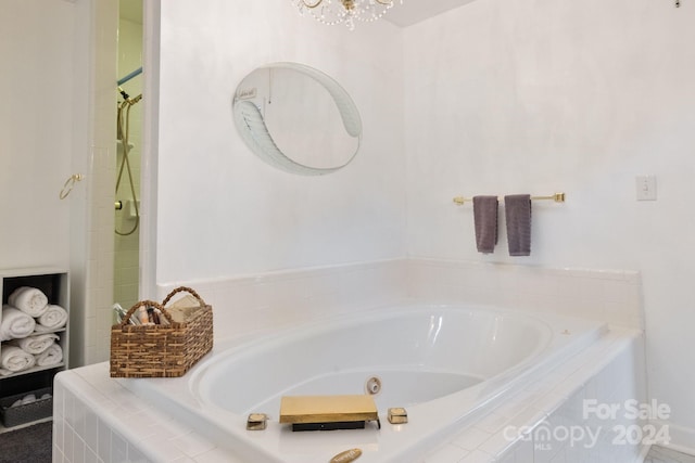 bathroom with an inviting chandelier and separate shower and tub