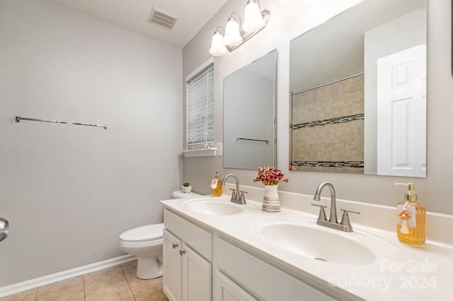 bathroom with vanity, toilet, a textured ceiling, and tile patterned floors