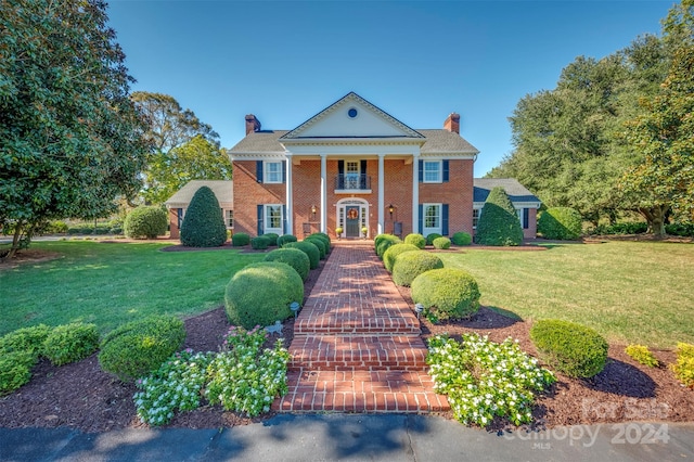 greek revival inspired property featuring french doors and a front yard