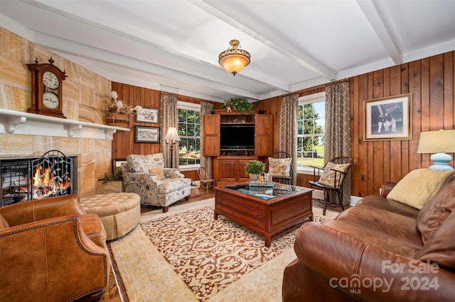 living room featuring wood walls and beamed ceiling