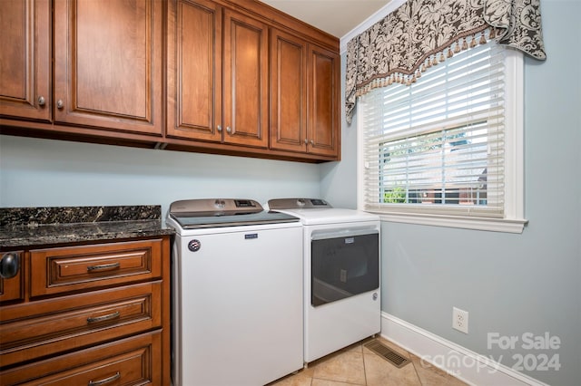 washroom with cabinets, light tile patterned flooring, and washer and clothes dryer