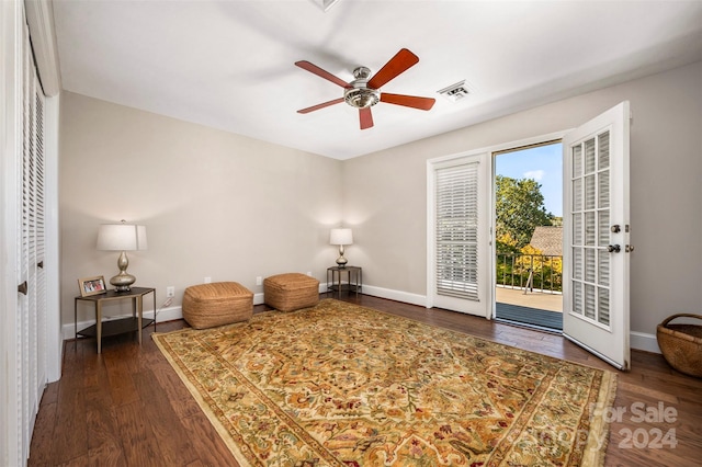 living area featuring dark hardwood / wood-style floors and ceiling fan