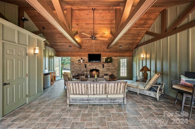 living room with ceiling fan, high vaulted ceiling, wooden ceiling, and a fireplace