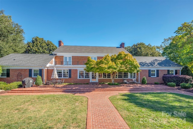 colonial inspired home featuring a front lawn