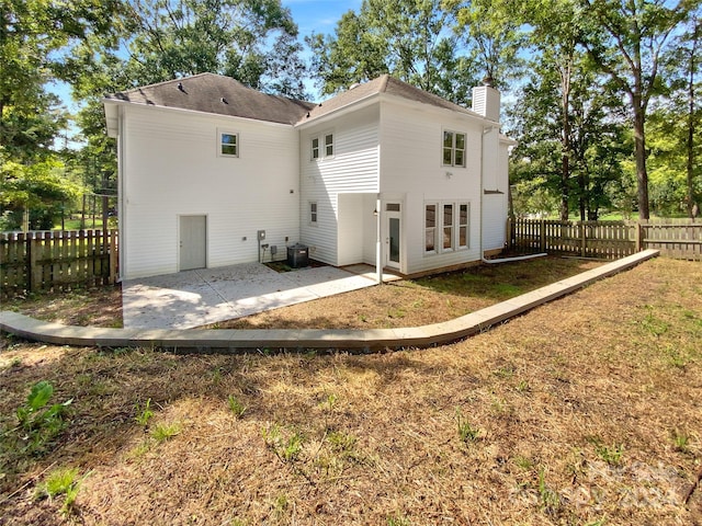 back of property featuring a yard, cooling unit, and a patio area