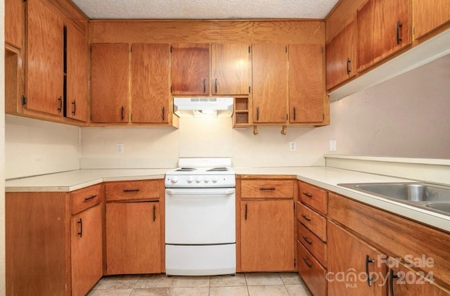 kitchen featuring a textured ceiling, white stove, light tile patterned flooring, and sink