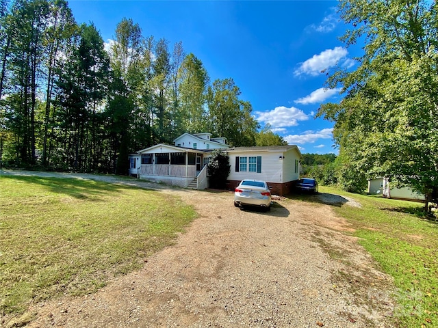 view of front of house featuring a sunroom and a front lawn