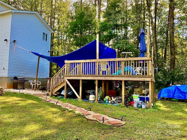 rear view of property featuring a wooden deck and a yard