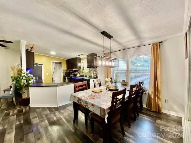 dining room featuring ceiling fan, a textured ceiling, crown molding, and dark wood-type flooring