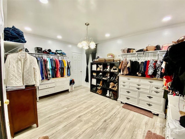 spacious closet featuring a notable chandelier and light hardwood / wood-style floors