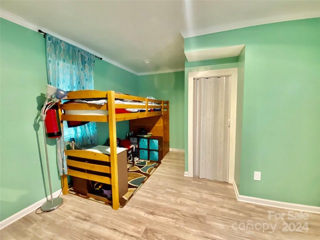 bedroom with hardwood / wood-style floors and crown molding