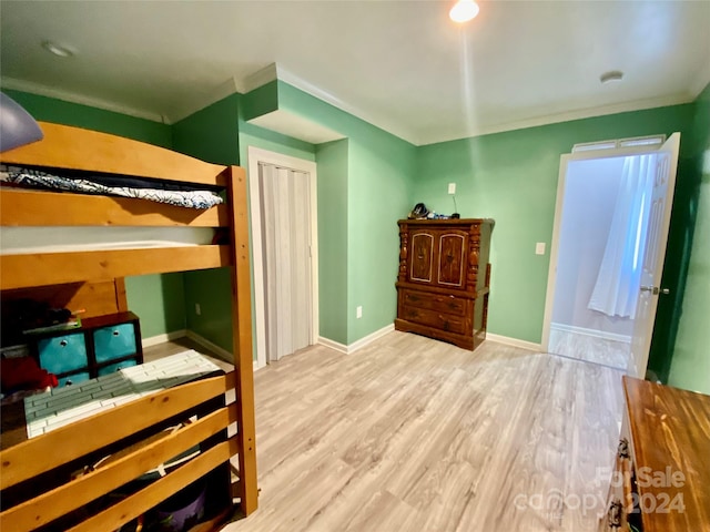 bedroom with crown molding and light hardwood / wood-style floors