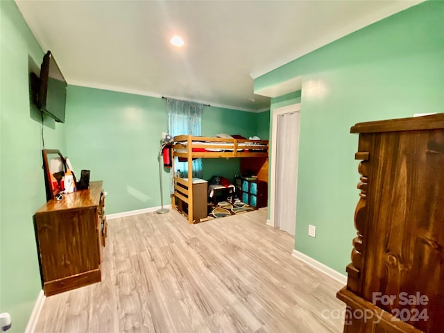 bedroom with light hardwood / wood-style floors and crown molding