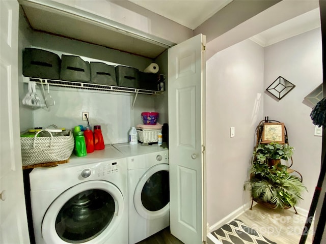 laundry area with crown molding, separate washer and dryer, and hardwood / wood-style floors