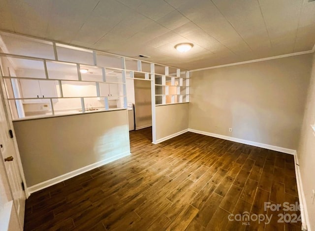 empty room with ornamental molding and dark wood-type flooring