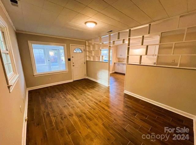 foyer entrance with ornamental molding and dark hardwood / wood-style flooring