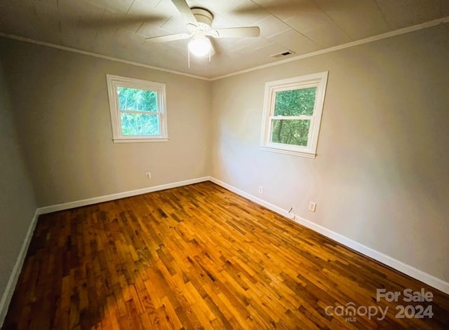 empty room with ceiling fan, hardwood / wood-style flooring, and crown molding