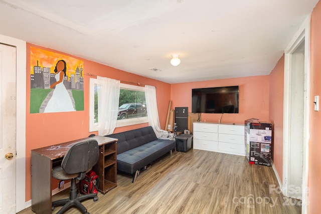 home office with light hardwood / wood-style flooring