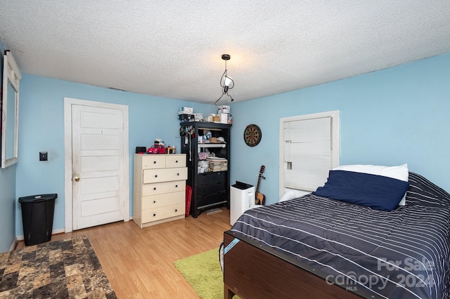 bedroom featuring a textured ceiling and hardwood / wood-style floors