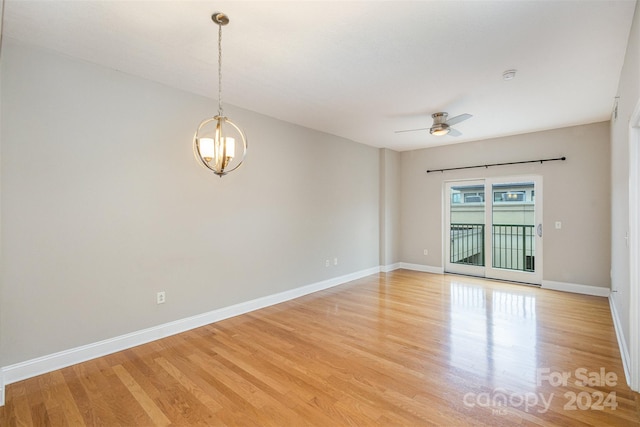 unfurnished room featuring ceiling fan with notable chandelier and light hardwood / wood-style flooring