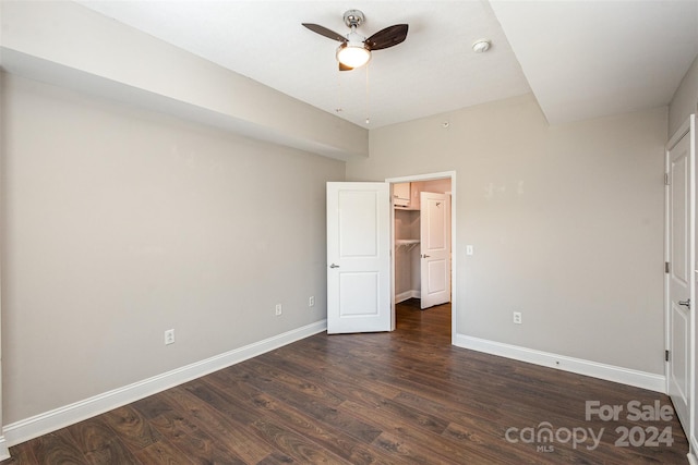 unfurnished bedroom with ceiling fan and dark wood-type flooring