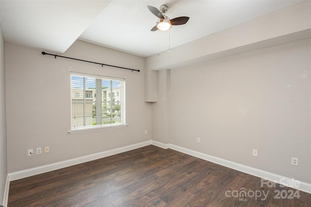 empty room with ceiling fan and dark hardwood / wood-style flooring