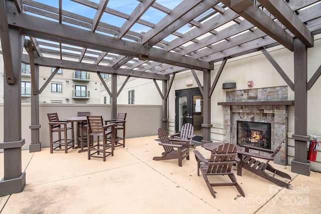 view of patio featuring a stone fireplace and a pergola