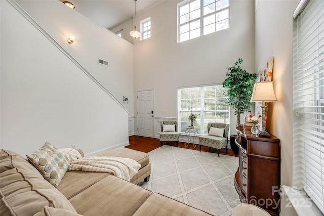 living room featuring a towering ceiling and light wood-type flooring