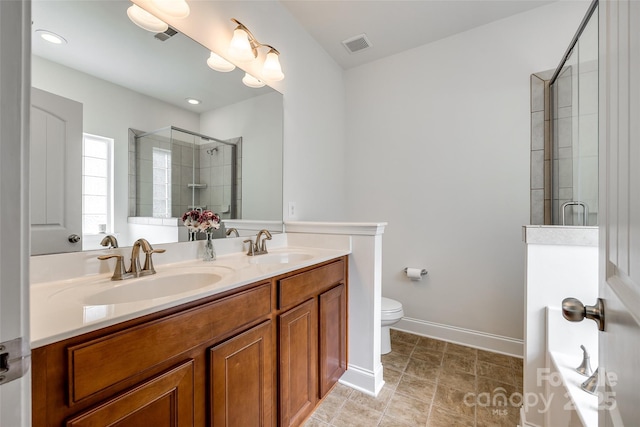 bathroom with walk in shower, vanity, and toilet