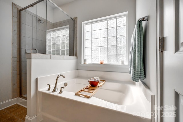 bathroom with plenty of natural light and separate shower and tub