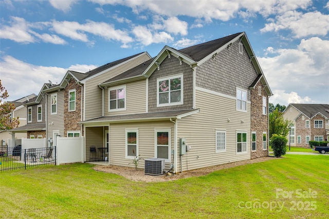 rear view of house featuring a yard, central AC unit, and a patio area