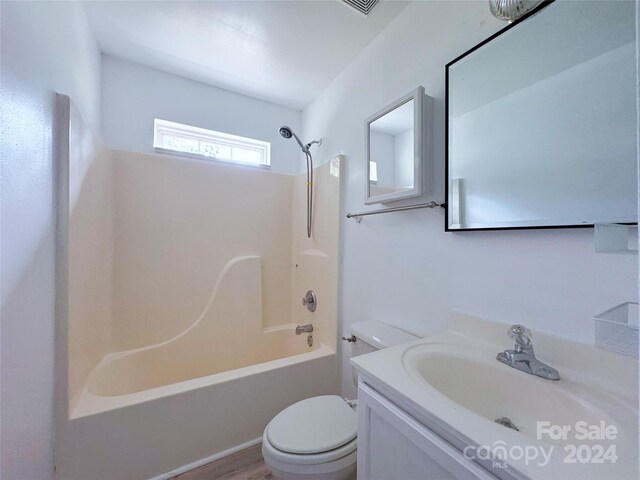 full bathroom with hardwood / wood-style floors, vanity, toilet, and  shower combination