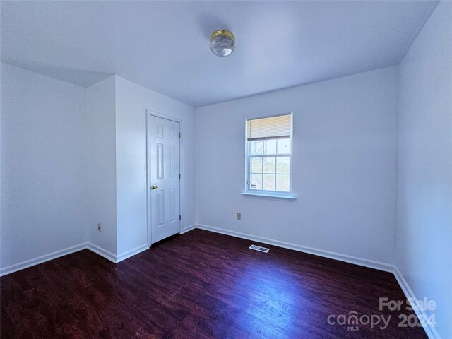 unfurnished room with dark hardwood / wood-style floors