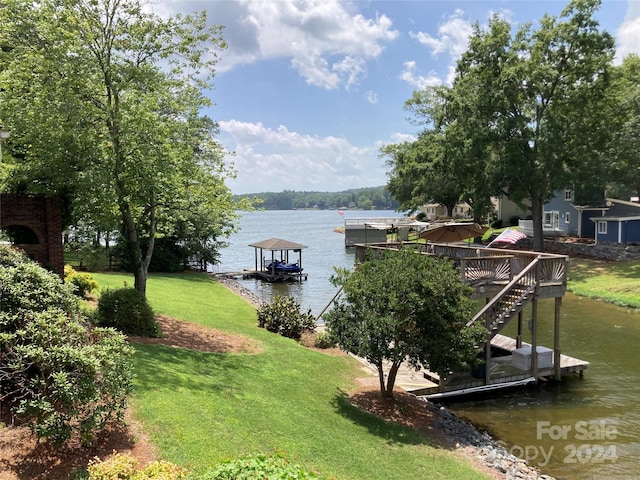 dock area featuring a lawn and a water view