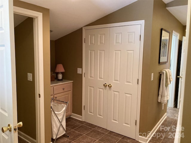 interior space featuring vaulted ceiling and dark tile patterned flooring