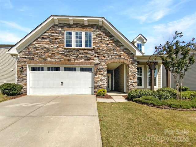 view of front of house featuring a garage and a front lawn