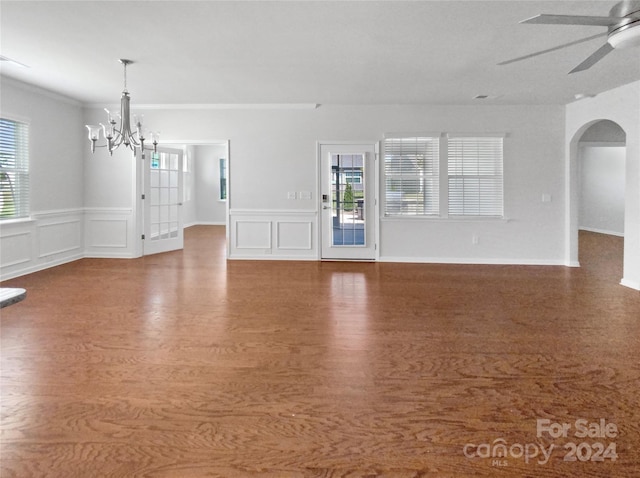 unfurnished living room with wood-type flooring, ceiling fan with notable chandelier, and crown molding