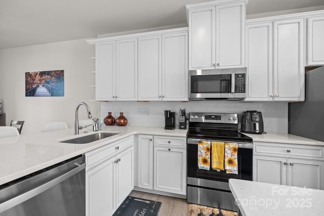 kitchen featuring white cabinets, backsplash, sink, and stainless steel appliances