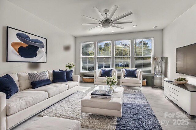 living room with ceiling fan and light hardwood / wood-style floors