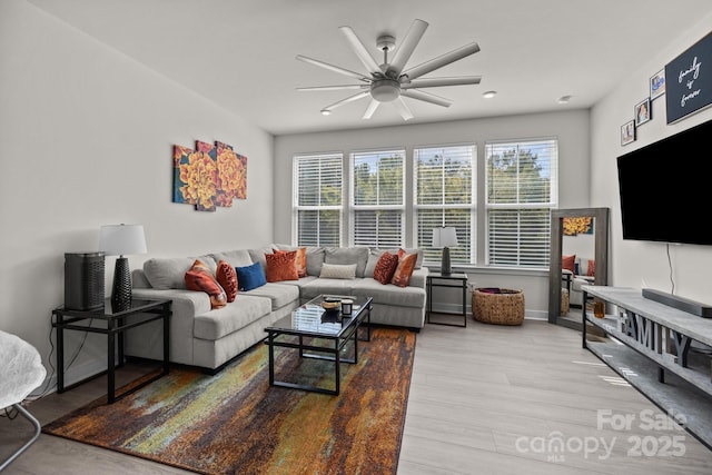 living room with ceiling fan and light hardwood / wood-style flooring