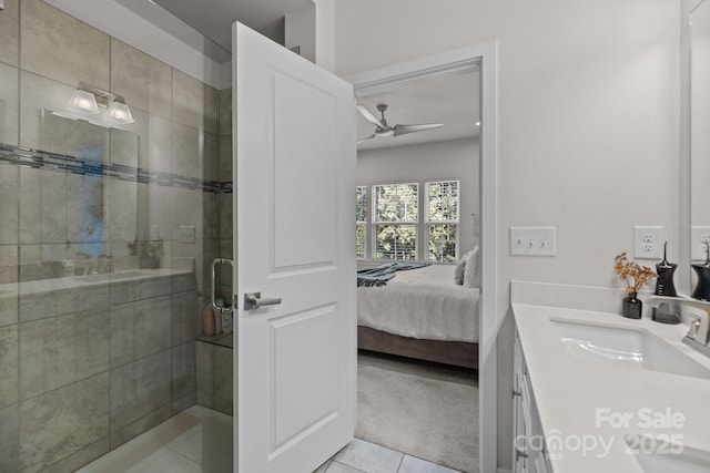 bathroom with tile patterned floors, ceiling fan, a shower with door, and vanity