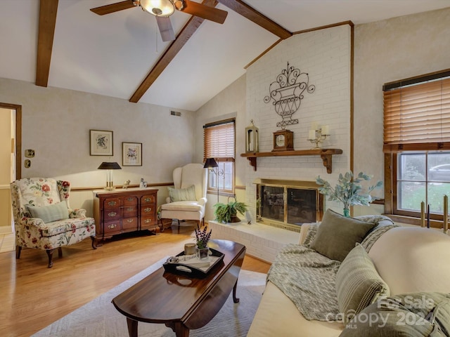 living room featuring light wood-type flooring, a fireplace, and beam ceiling