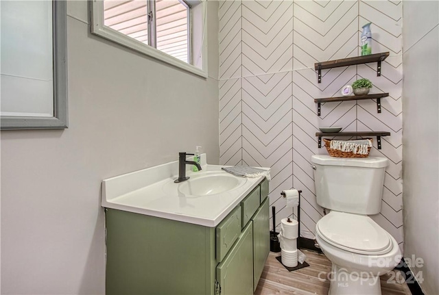 bathroom featuring wood-type flooring, vanity, and toilet