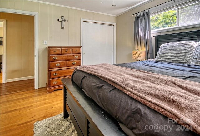 bedroom featuring ornamental molding, a closet, and hardwood / wood-style flooring