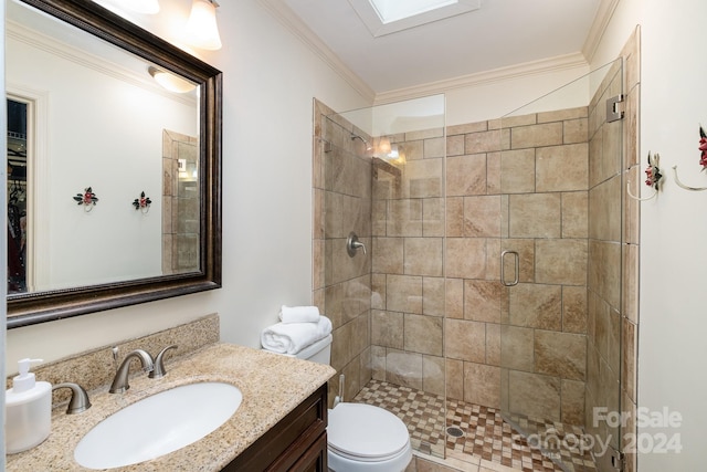 bathroom featuring a skylight, a shower with door, ornamental molding, vanity, and toilet