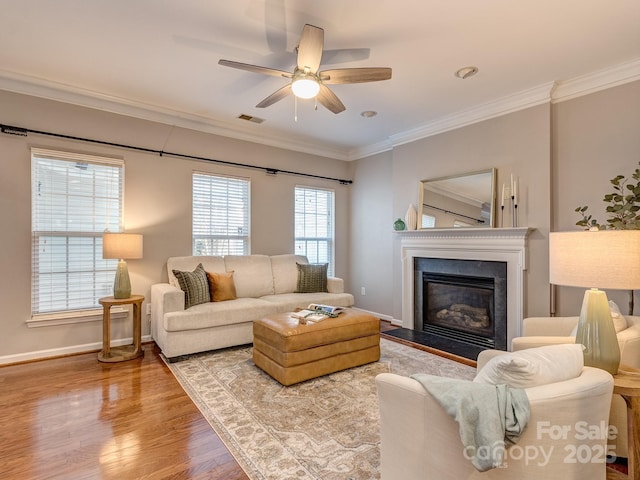 living room with ornamental molding, ceiling fan, and light wood-type flooring