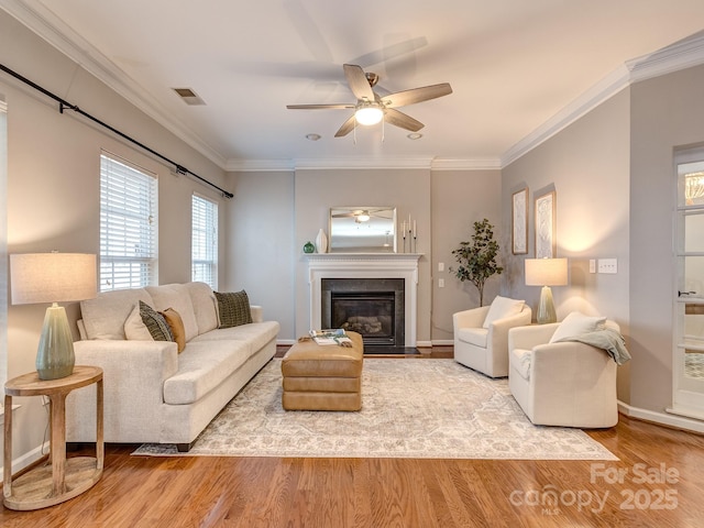 living room with crown molding, hardwood / wood-style floors, and ceiling fan