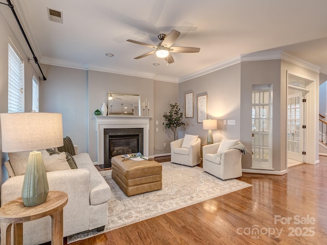 living room with crown molding, hardwood / wood-style floors, and ceiling fan