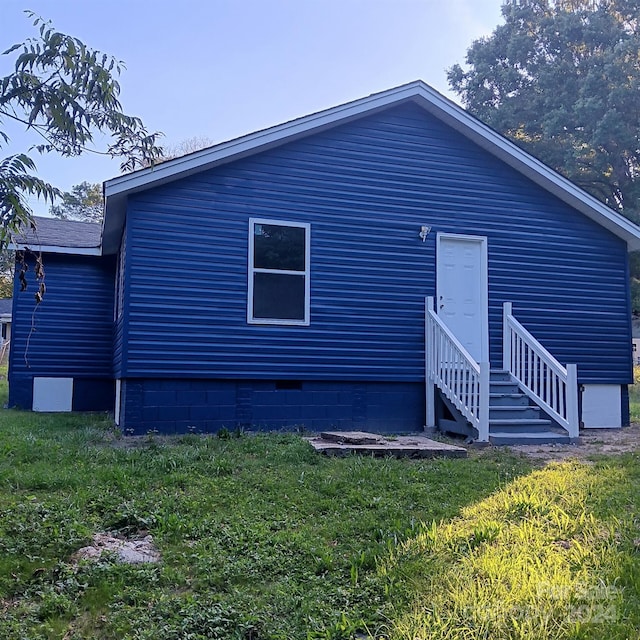 rear view of property featuring a lawn